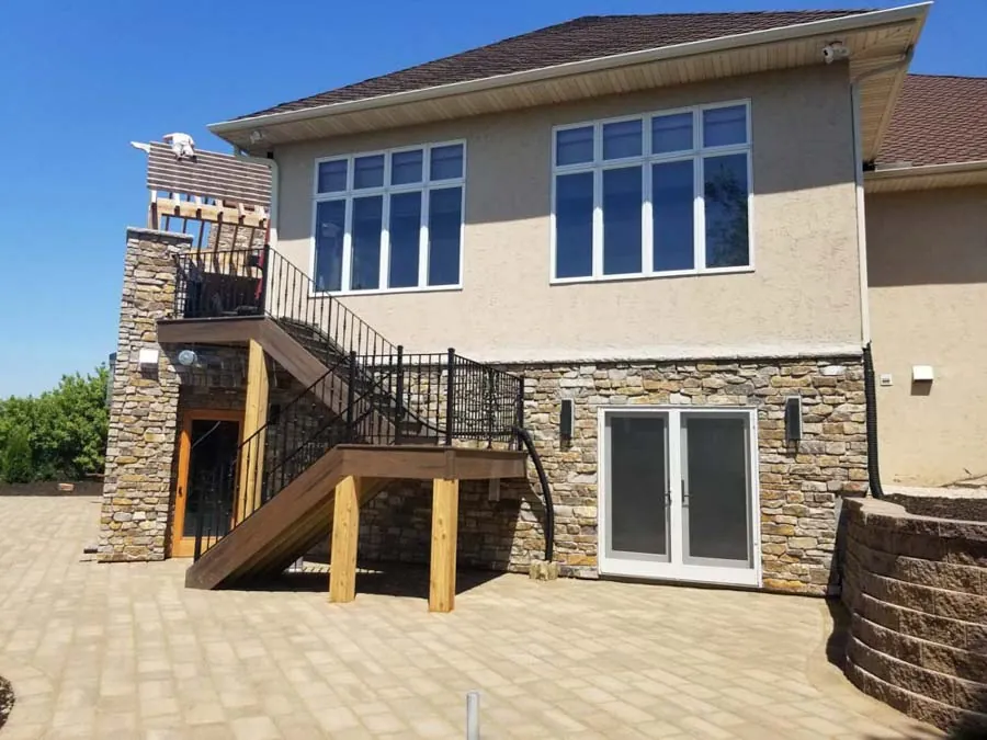 Rear home addition with stone base by BN Builders