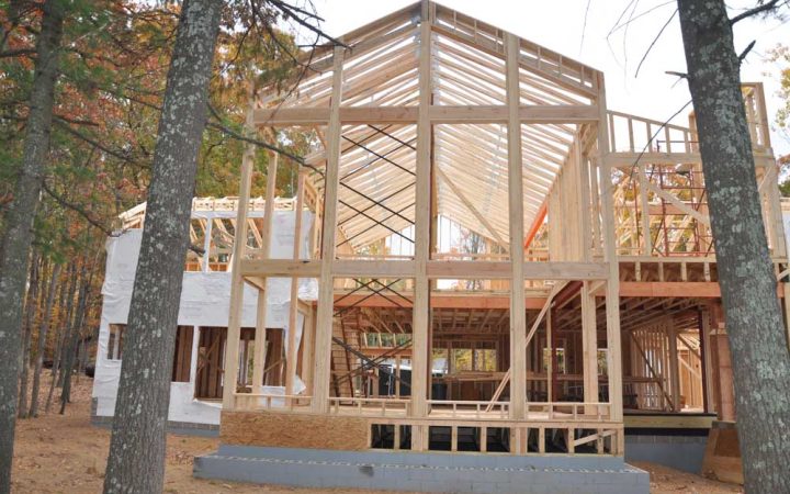 Post frames built in an ongoing construction of house in the middle of a forested area