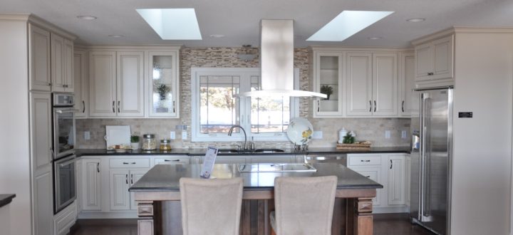 U-shaped kitchen with island: appliances fitted adjacent to built-in cabinets, mosaic-tile backsplash, a wood island with marble countertop