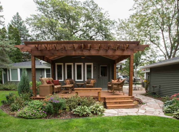 A deck with pergola and chairs for relaxation and outdoor conversations, and a flagstone path to the backyard